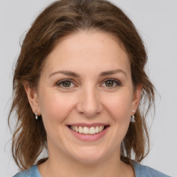 Joyful white young-adult female with medium  brown hair and grey eyes