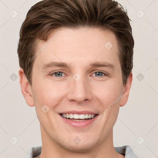 Joyful white young-adult male with short  brown hair and grey eyes