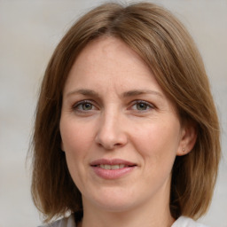 Joyful white adult female with medium  brown hair and grey eyes