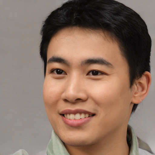 Joyful asian young-adult male with short  black hair and brown eyes
