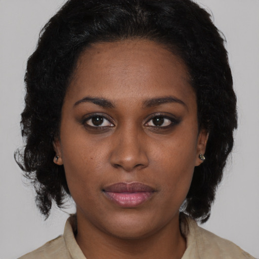 Joyful black young-adult female with medium  brown hair and brown eyes