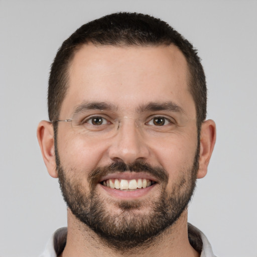 Joyful white young-adult male with short  black hair and brown eyes