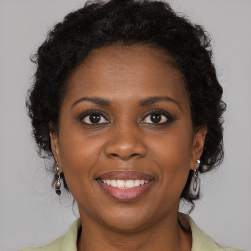 Joyful black young-adult female with long  brown hair and brown eyes