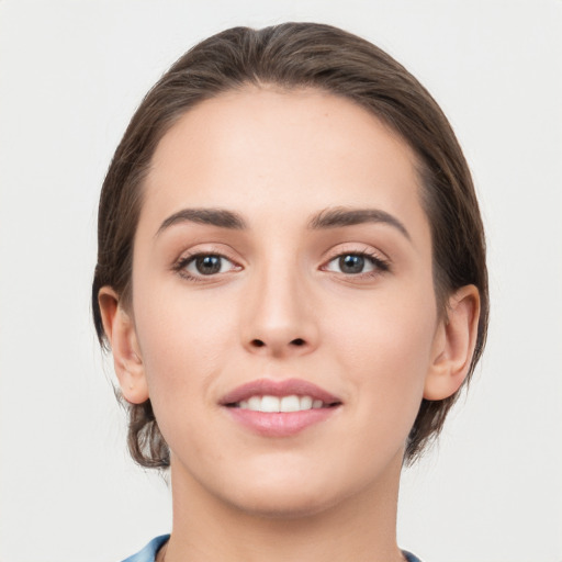 Joyful white young-adult female with medium  brown hair and grey eyes