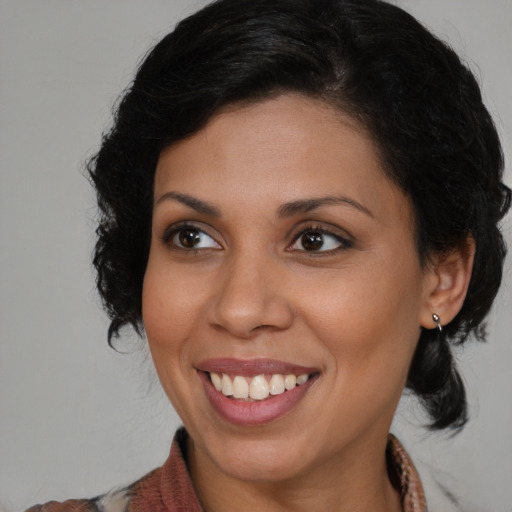 Joyful black young-adult female with medium  brown hair and brown eyes