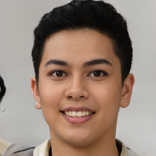 Joyful latino young-adult male with short  brown hair and brown eyes
