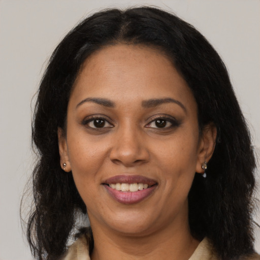 Joyful black adult female with long  brown hair and brown eyes