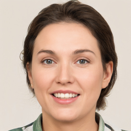 Joyful white young-adult female with medium  brown hair and grey eyes