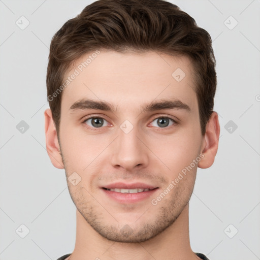 Joyful white young-adult male with short  brown hair and grey eyes