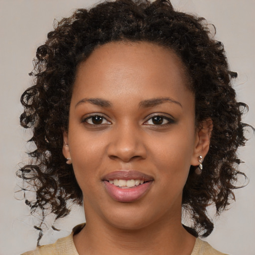 Joyful black young-adult female with medium  brown hair and brown eyes