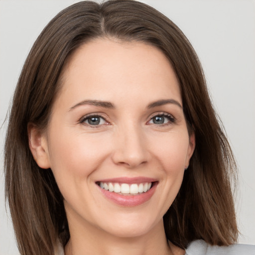 Joyful white young-adult female with long  brown hair and grey eyes