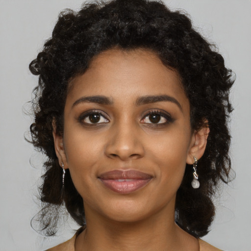 Joyful black young-adult female with long  black hair and brown eyes