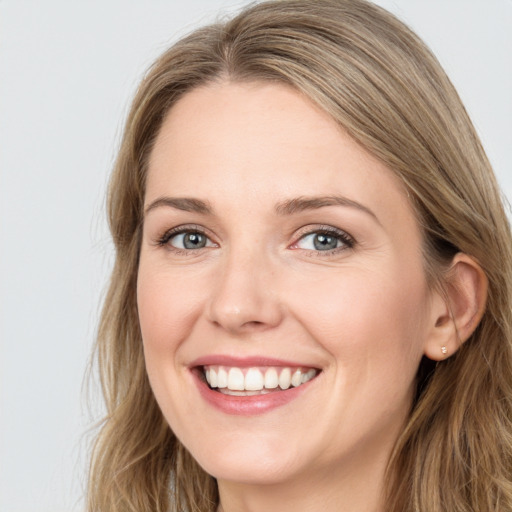 Joyful white young-adult female with long  brown hair and blue eyes