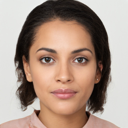 Joyful latino young-adult female with medium  brown hair and brown eyes