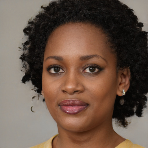 Joyful black young-adult female with medium  black hair and brown eyes
