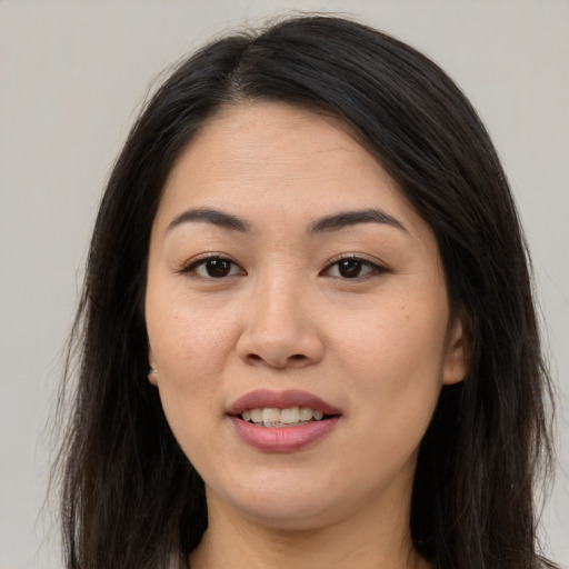 Joyful white young-adult female with long  brown hair and brown eyes