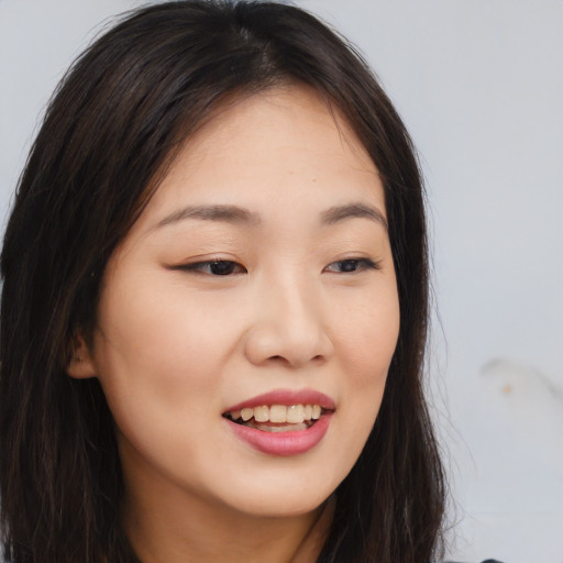 Joyful asian young-adult female with long  brown hair and brown eyes