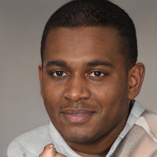 Joyful black young-adult male with short  brown hair and brown eyes