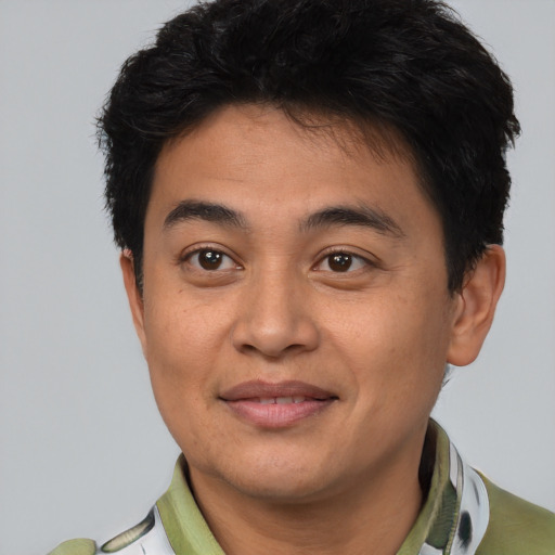 Joyful latino young-adult male with short  black hair and brown eyes