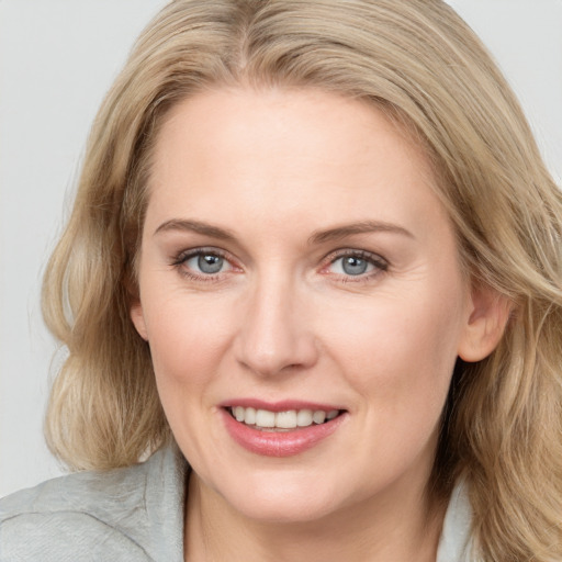 Joyful white adult female with medium  brown hair and blue eyes