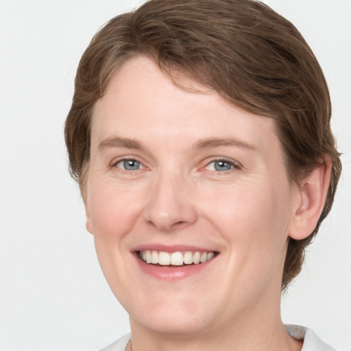 Joyful white young-adult female with medium  brown hair and grey eyes