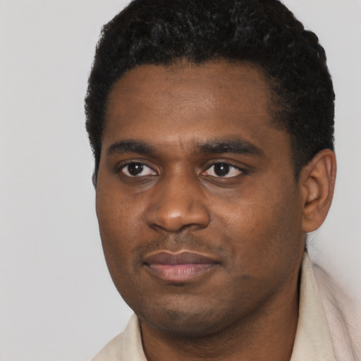 Joyful black young-adult male with short  black hair and brown eyes