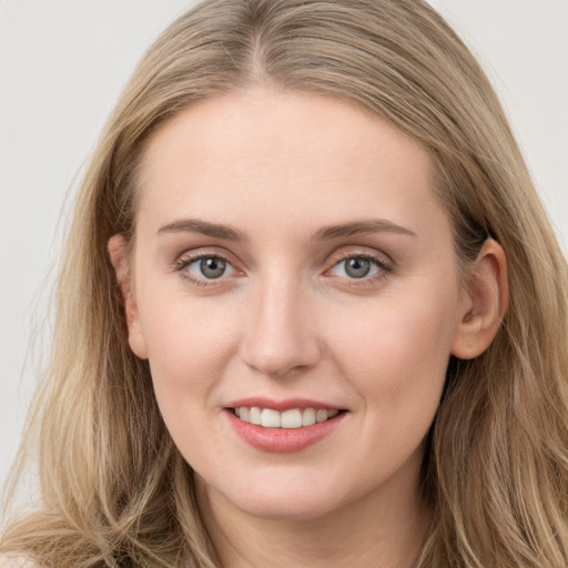 Joyful white young-adult female with long  brown hair and blue eyes