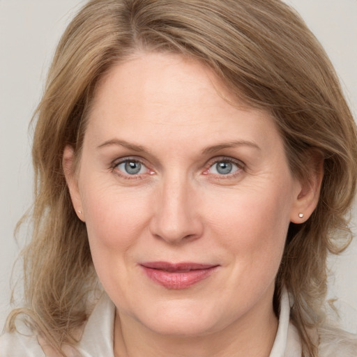 Joyful white adult female with medium  brown hair and grey eyes