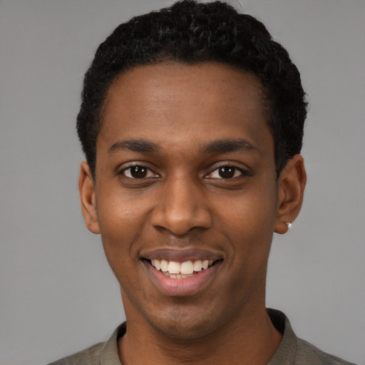 Joyful black young-adult male with short  black hair and brown eyes