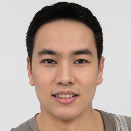 Joyful asian young-adult male with short  black hair and brown eyes