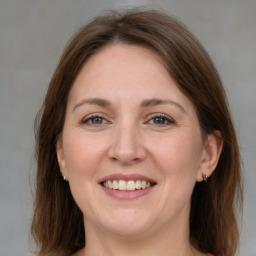 Joyful white adult female with medium  brown hair and grey eyes