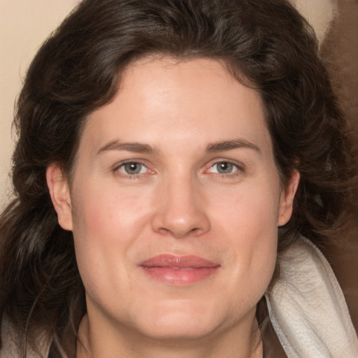 Joyful white adult female with long  brown hair and grey eyes