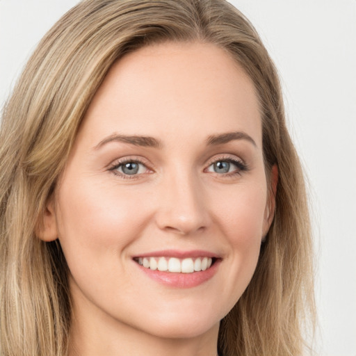 Joyful white young-adult female with long  brown hair and green eyes