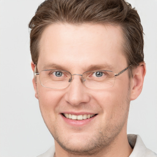 Joyful white adult male with short  brown hair and grey eyes