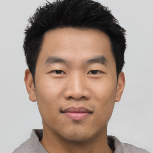 Joyful asian young-adult male with short  black hair and brown eyes