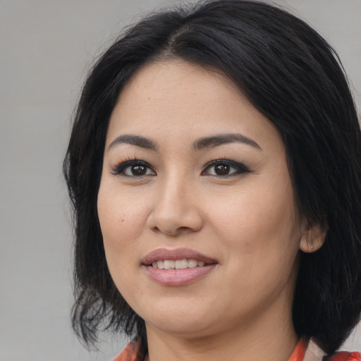 Joyful asian young-adult female with medium  black hair and brown eyes