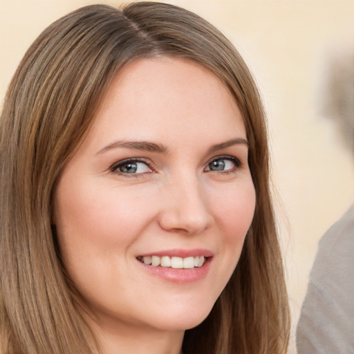 Joyful white young-adult female with long  brown hair and brown eyes