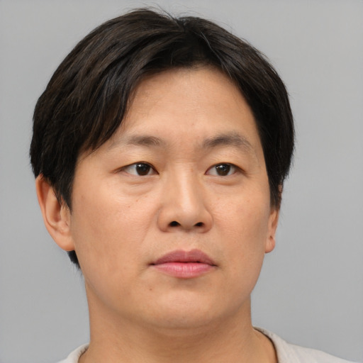 Joyful asian adult male with short  brown hair and brown eyes