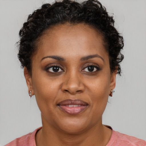 Joyful black adult female with short  brown hair and brown eyes