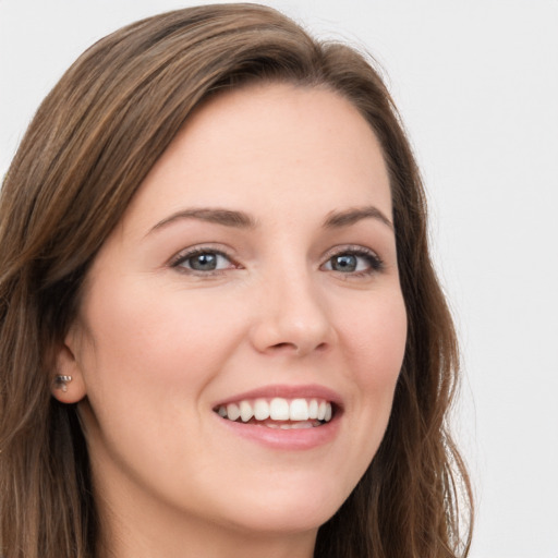 Joyful white young-adult female with long  brown hair and grey eyes