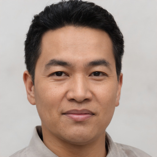 Joyful asian adult male with short  black hair and brown eyes