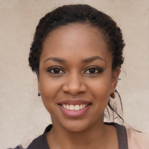 Joyful black young-adult female with long  black hair and brown eyes