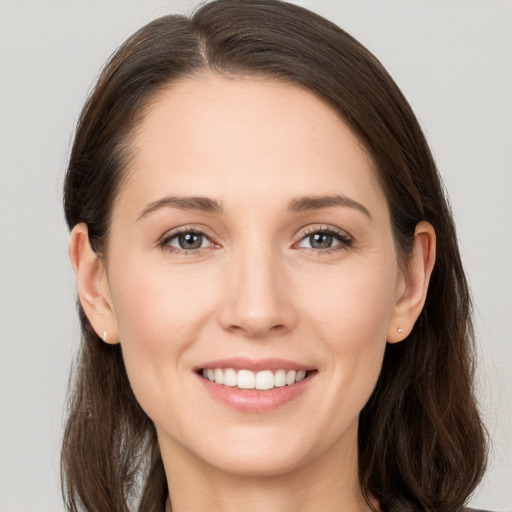 Joyful white young-adult female with long  brown hair and grey eyes