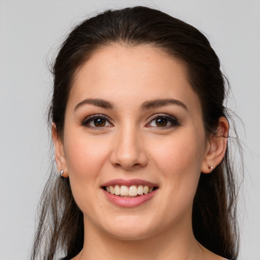 Joyful white young-adult female with long  brown hair and brown eyes