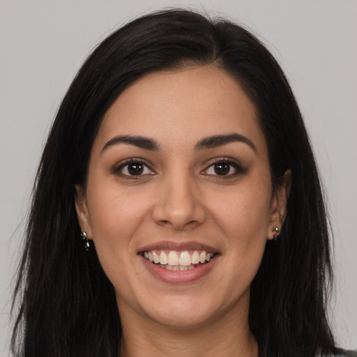 Joyful latino young-adult female with long  brown hair and brown eyes