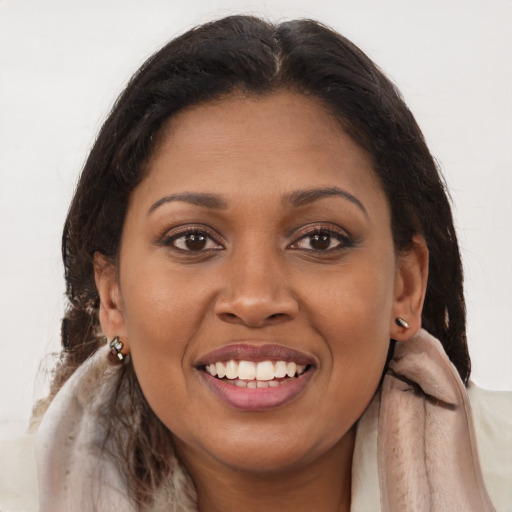 Joyful black young-adult female with long  brown hair and brown eyes
