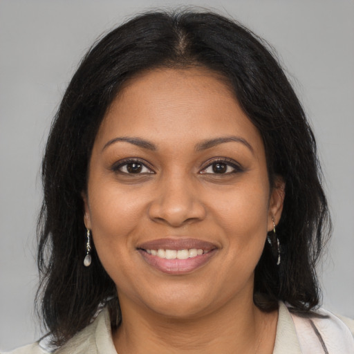 Joyful black young-adult female with medium  brown hair and brown eyes