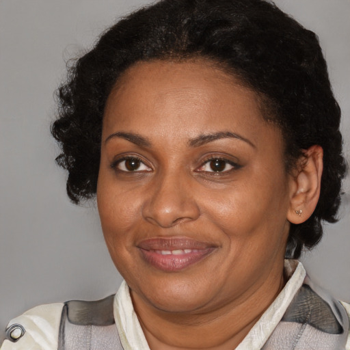 Joyful black adult female with short  brown hair and brown eyes