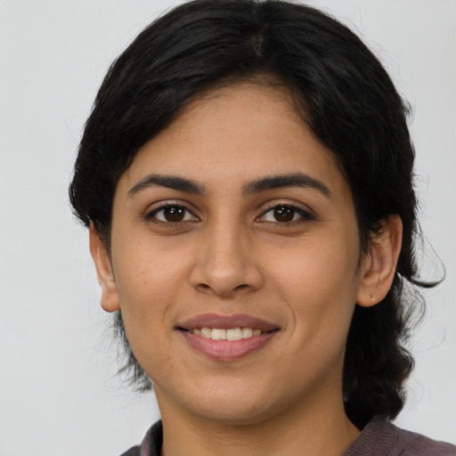 Joyful latino young-adult female with medium  black hair and brown eyes