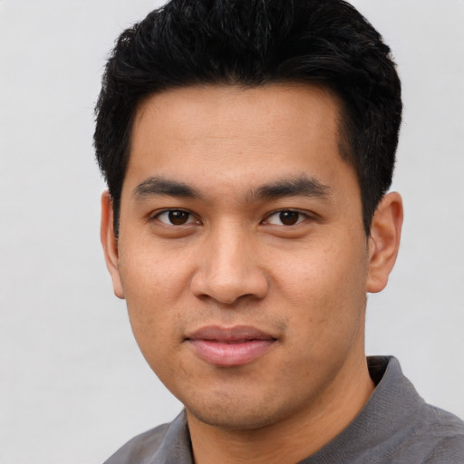 Joyful asian young-adult male with short  black hair and brown eyes